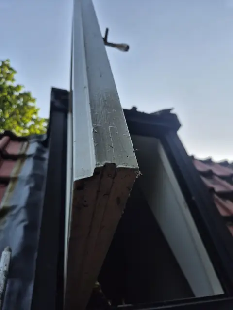 Houtrot in het kozijn van een dakraam, waar de verflaag is losgelaten