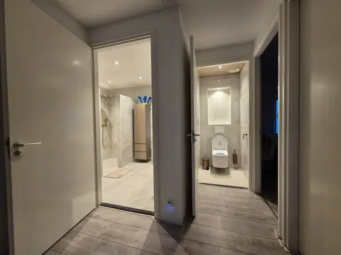 Badkamer en apart toilet naast elkaar aan de overloop, allebei in marmerlook-tegels