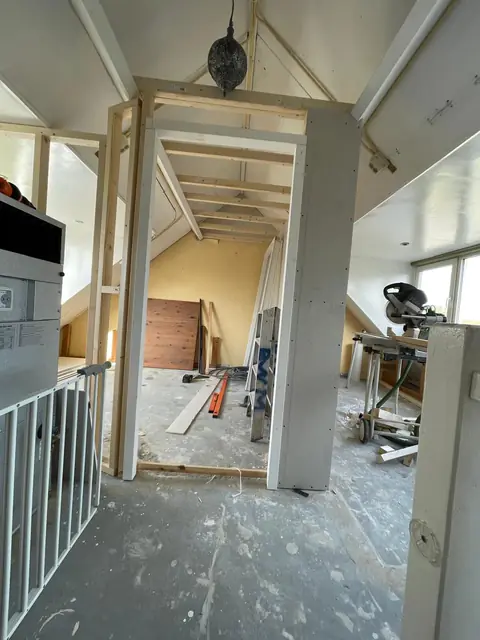 Metal- en houtstudwerk voor de nieuwe wanden op zolder, met de leidingen al weggewerkt
